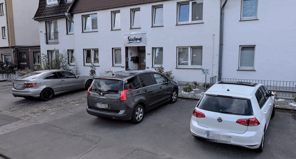 Autos vor einem Haus auf dem Parkplatz